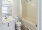 Thumbnail 9 of 16 - A white bathroom with a toilet, sink, and bathtub.