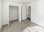 Thumbnail 6 of 16 - A white room with a carpeted floor and two doors.
