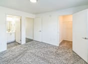 Thumbnail 4 of 16 - A white room with a carpeted floor and three doors.