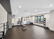 Thumbnail 20 of 34 - A spacious home gym with a bench, weights, and exercise equipment.