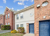 Thumbnail 18 of 25 - A red brick building with a white door and windows.