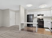 Thumbnail 3 of 34 - A kitchen with black appliances and white cabinets.
