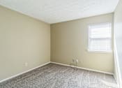 Thumbnail 11 of 20 - A room with a carpeted floor and a window with blinds.