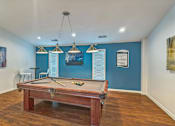 Thumbnail 18 of 20 - A pool table in a room with blue walls.