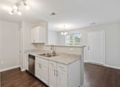 Thumbnail 1 of 25 - A kitchen with white cabinets and a wooden floor.