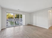 Thumbnail 6 of 26 - A room with a sliding glass door leading to a balcony.