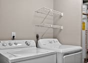 Thumbnail 7 of 34 - A white washing machine and dryer in a laundry room.
