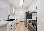 Thumbnail 1 of 31 - A kitchen with black appliances and white cabinets.