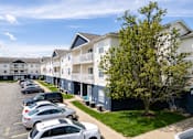 Thumbnail 4 of 39 - a row of apartment buildings with cars parked in front of them