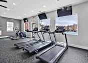 Thumbnail 16 of 38 - A gym with treadmills and elliptical machines.