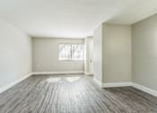 Thumbnail 7 of 30 - Empty room with wooden flooring and a window.