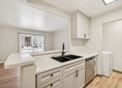 Thumbnail 2 of 31 - A kitchen with a white counter top and a window.