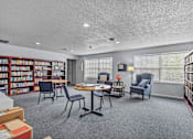 Thumbnail 36 of 39 - a library with a round table and chairs