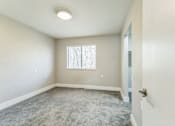 Thumbnail 12 of 30 - A room with a carpeted floor and a window.