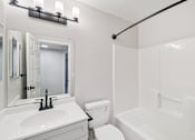Thumbnail 7 of 31 - A white bathroom with a toilet, sink, and bathtub.