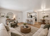 Thumbnail 8 of 39 - A living room with a grey couch and a coffee table in the middle.