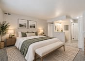 Thumbnail 11 of 39 - A bedroom with a large bed and two framed pictures on the wall.