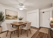 Thumbnail 10 of 35 - A dining room with a wooden table and chairs.