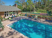 Thumbnail 2 of 37 - A pool surrounded by a fence with a tennis court in the background.