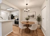 Thumbnail 5 of 39 - A modern kitchen with a dining table and chairs.
