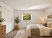 Thumbnail 14 of 35 - A bedroom with a large bed and a window.