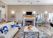 Thumbnail 13 of 21 - Cozy community clubhouse living room with fireplace and white couch at Cambury Hills Apartments in Omaha, Nebraska