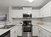 Thumbnail 14 of 39 - A kitchen with white cabinets and a black stove top oven.