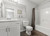 Thumbnail 11 of 39 - A white bathroom with a toilet, sink, and bathtub.