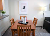 Thumbnail 35 of 38 - A wooden dining table with four chairs and a tray with glasses and a mug on it.