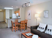 Thumbnail 20 of 38 - A living room with a dining table and chairs.