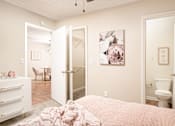 Thumbnail 5 of 22 - Cozy bedroom with bed, dresser, and wall art at Southwind Apartments in Richland, MS.