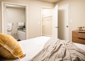 Thumbnail 11 of 22 - Bedroom with bed, dresser, and mirror at Southwind Apartments in Richland, MS.