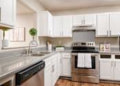 Thumbnail 3 of 22 - Stainless steel appliances and crisp white cabinetry in a Southwind Apartments kitchen in Richland, MS.