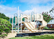 Thumbnail 21 of 22 - Community playground featuring a slide and climbing structures at Southwind Apartments in Richland, MS.