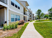 Thumbnail 7 of 10 - Exterior view of residential apartment buildings with walkway at Waterbrook Apartments in Lincoln, Nebraska, professionally operated by Highlands Vista Group.