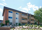 Thumbnail 14 of 16 - A modern apartment building with a red, white, and beige color scheme.
