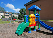 Thumbnail 11 of 16 - A playground with a blue slide and a yellow and red structure.
