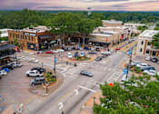Thumbnail 23 of 38 - A city intersection with cars and buildings.