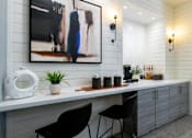 Thumbnail 31 of 38 - A modern kitchen with a large painting on the wall and two black chairs.