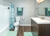 Thumbnail 7 of 37 - A white toilet sits next to a white sink in a bathroom.