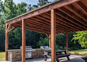 Thumbnail 14 of 24 - a pavilion with a stone fireplace and picnic table