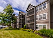 Thumbnail 29 of 39 - Apartment building with a green lawn in front.