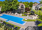 Thumbnail 22 of 39 - A swimming pool surrounded by a black fence and trees.