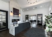 Thumbnail 34 of 39 - A reception area with a white reception desk and a grey rug.