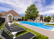 Thumbnail 25 of 39 - A pool with a slide and sun loungers in front of a house.
