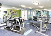 Thumbnail 15 of 20 - a gym with cardio equipment and weights at the monarch apartments in midtown