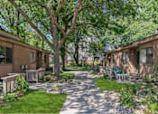 Thumbnail 29 of 30 - a walkway between two houses with trees and benches