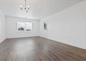 Thumbnail 8 of 18 - an empty living room with white walls and wood floors
