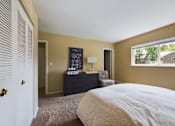 Thumbnail 10 of 22 - A bedroom with a bed, dresser, and window.