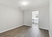 Thumbnail 3 of 29 - A room with light wood flooring and white walls.